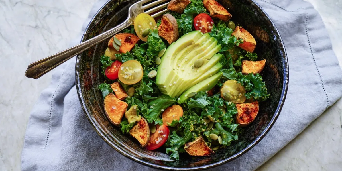 kale, roasted yams and avocado salad on stone background  vegan salad  healthy  paleo diet