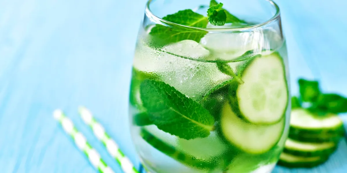 concombre maison et limonade à la menthe dans un verre sur un fond en bois bleu