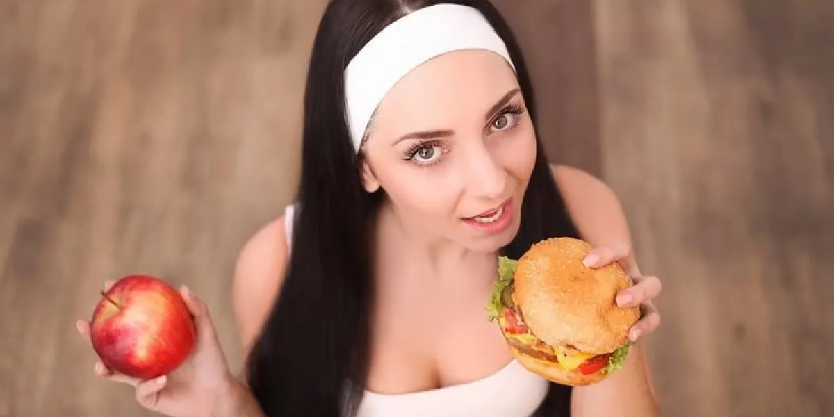 concept de santé, alimentation et alimentation - femme en bonne santé, sentant hamburger et tenant la pomme