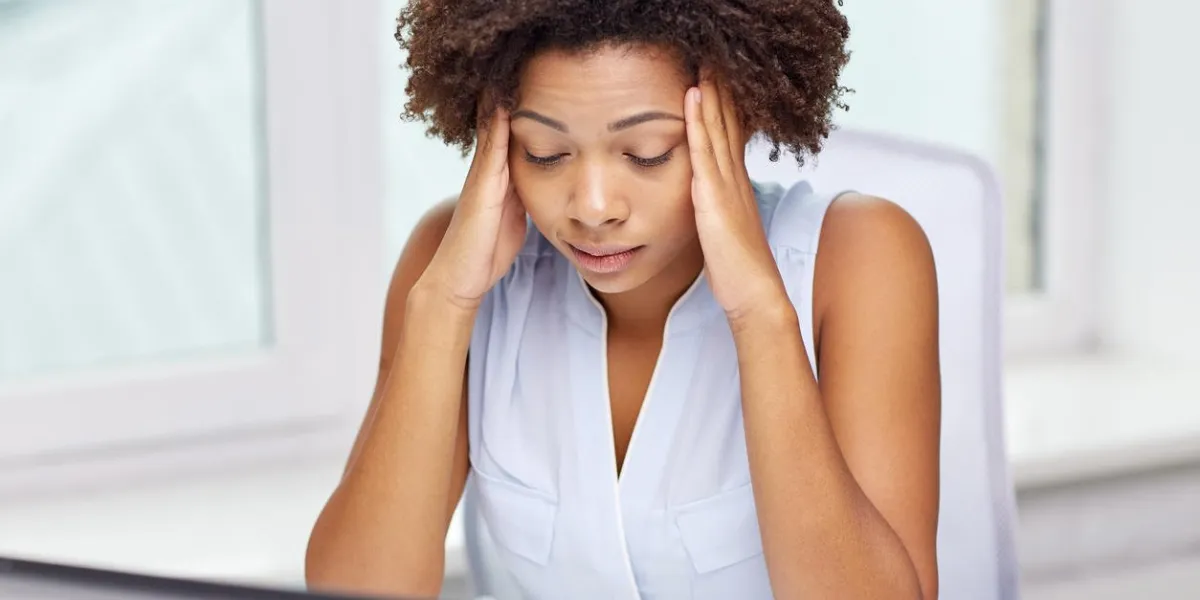 education, business, fail and technology concept - african american businesswoman or student with laptop computer and papers at office