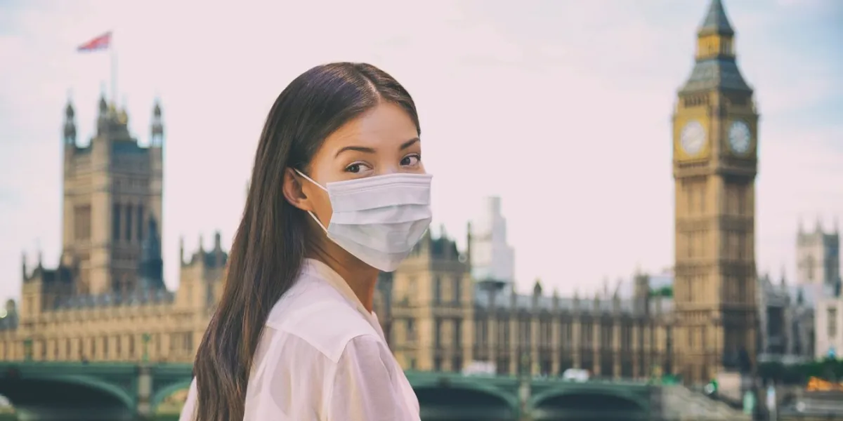 corona virus travel corona virus spread prevention asian woman tourist wearing protective face mask on uk london city sightseeing holiday vacation famous british landmark background panoramic