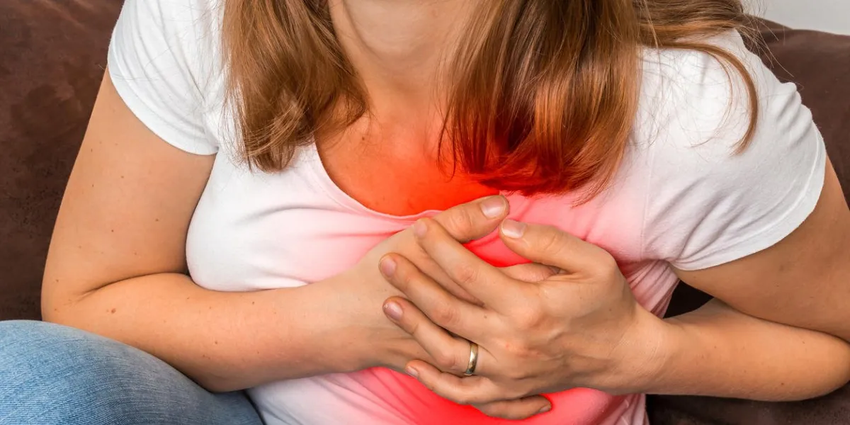woman on sofa having heart attack - chest pain