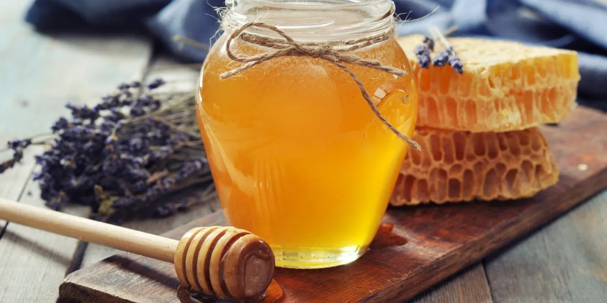 miel en pot avec une louche de miel sur fond en bois vintage