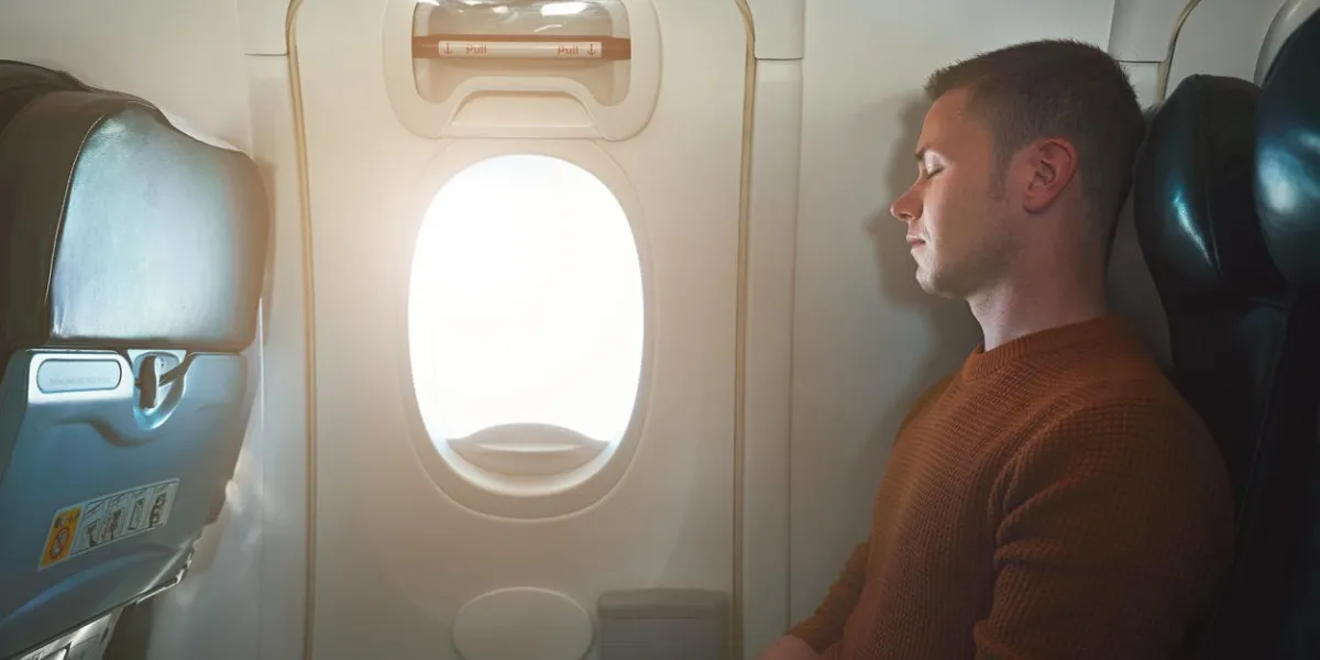 confortable voyager en avion jeune passager dormant sur le siège près de la sortie de secours de l'avion