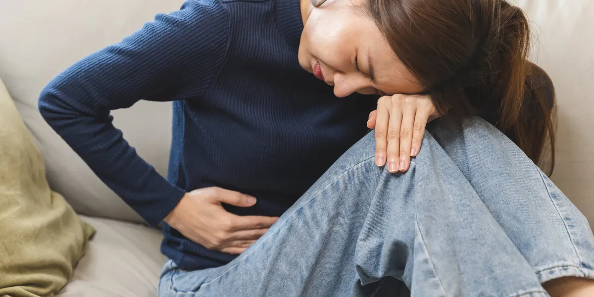 young woman gripping her stomach have abdominal pain