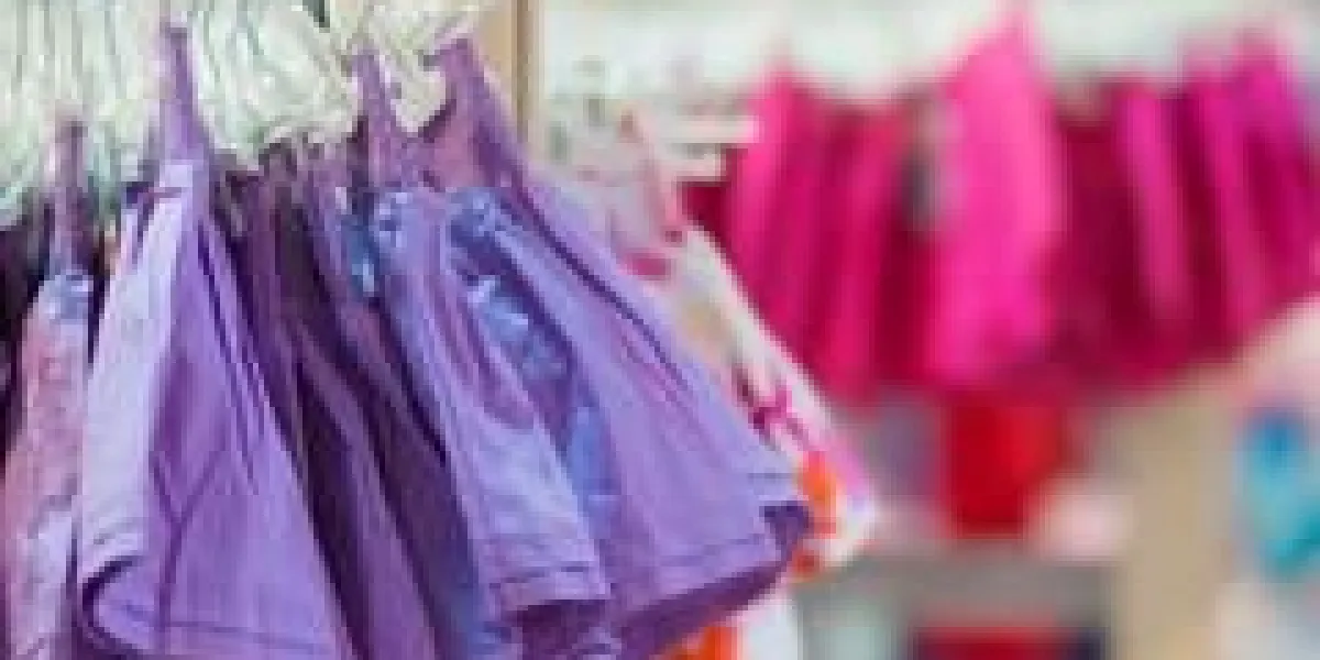 se dresse avec des vêtements dans le centre commercial pour enfants