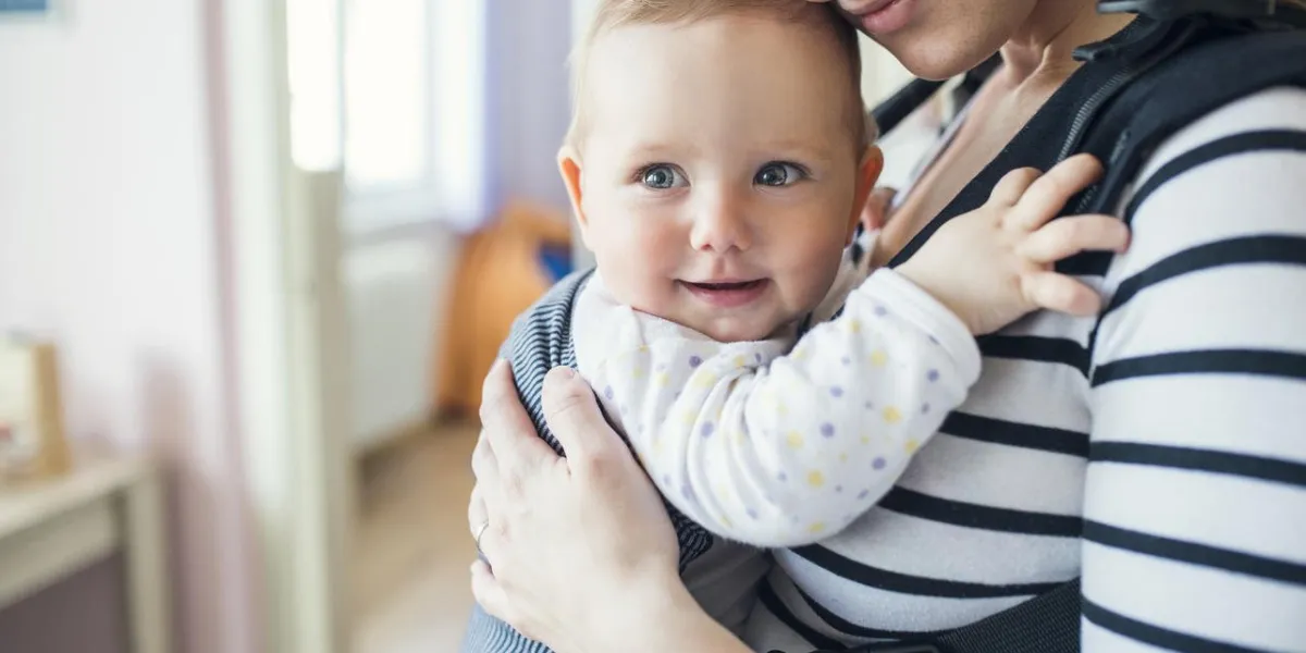 jeune mère ayant sa petite fille mignonne dans le porte-bébé