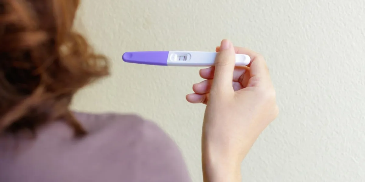 woman holding pregnancy test, new life and family planning concept