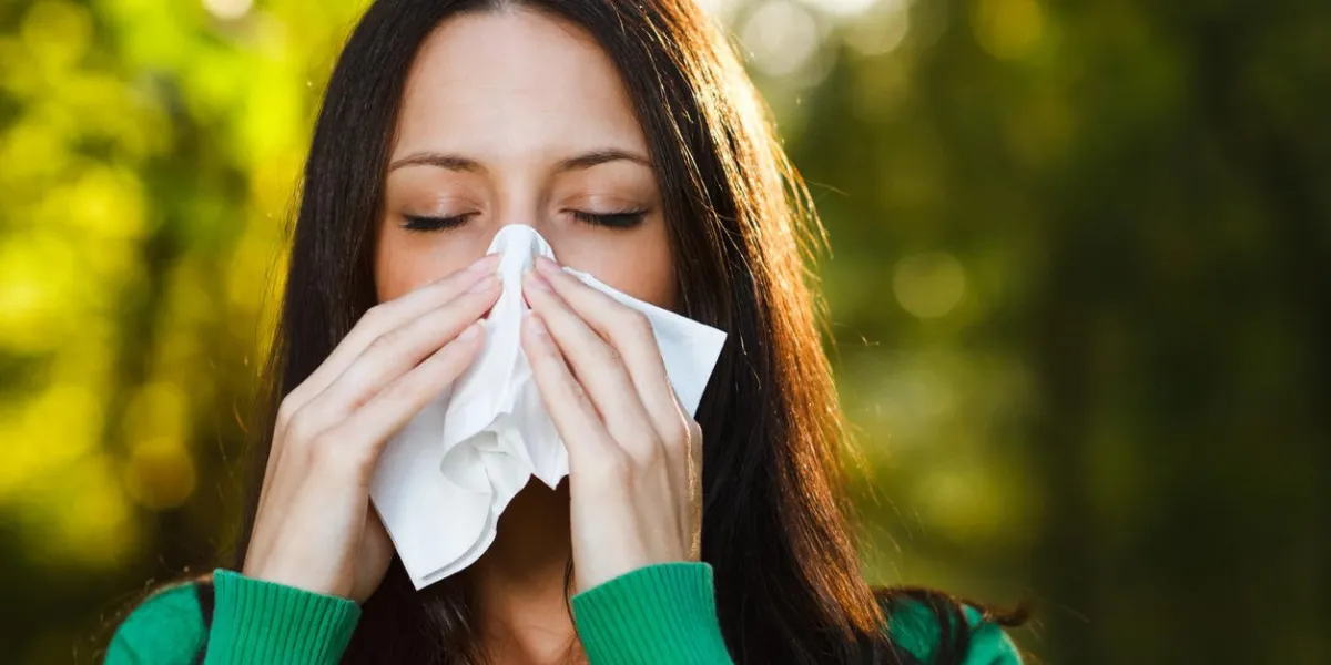 femme éternue dans un mouchoir