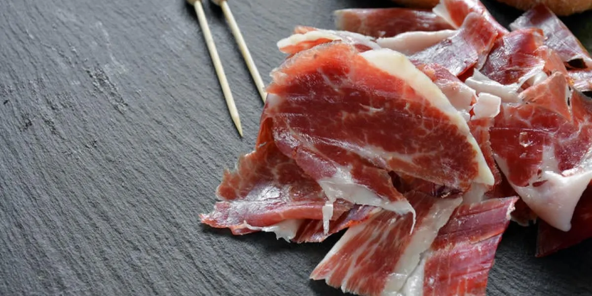 apéritif de jambon serrano avec du pain rôti et accompagné d'un verre de vin