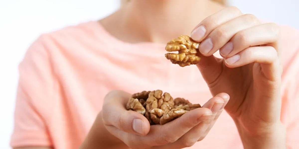 close up of woman eating walnuts
