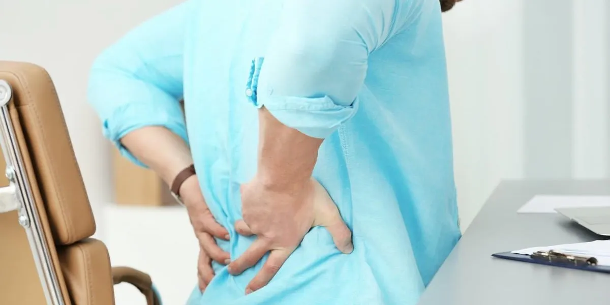 young man suffering from backache in office, closeup