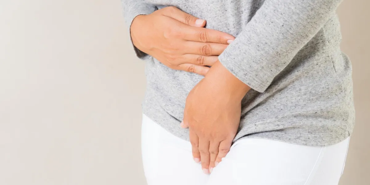 young woman having painful stomachache with hands holding pressing her crotch lower abdomen medical or gynecological problems, healthcare concept