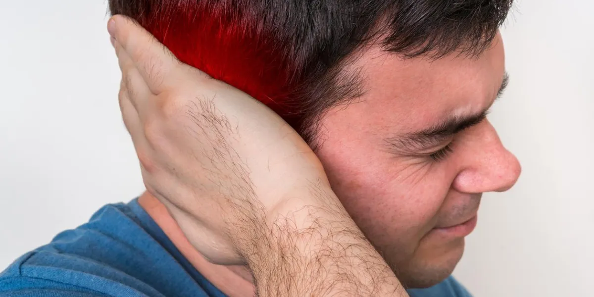 man with earache is holding his aching ear - body pain concept