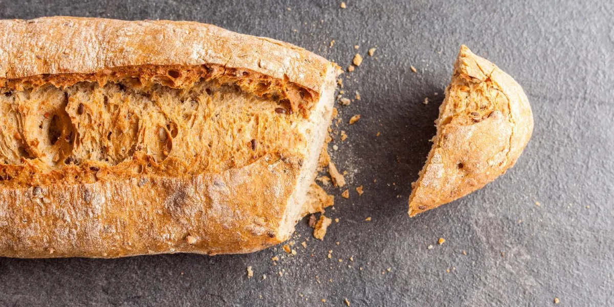 couper la miche de pain sur fond gris