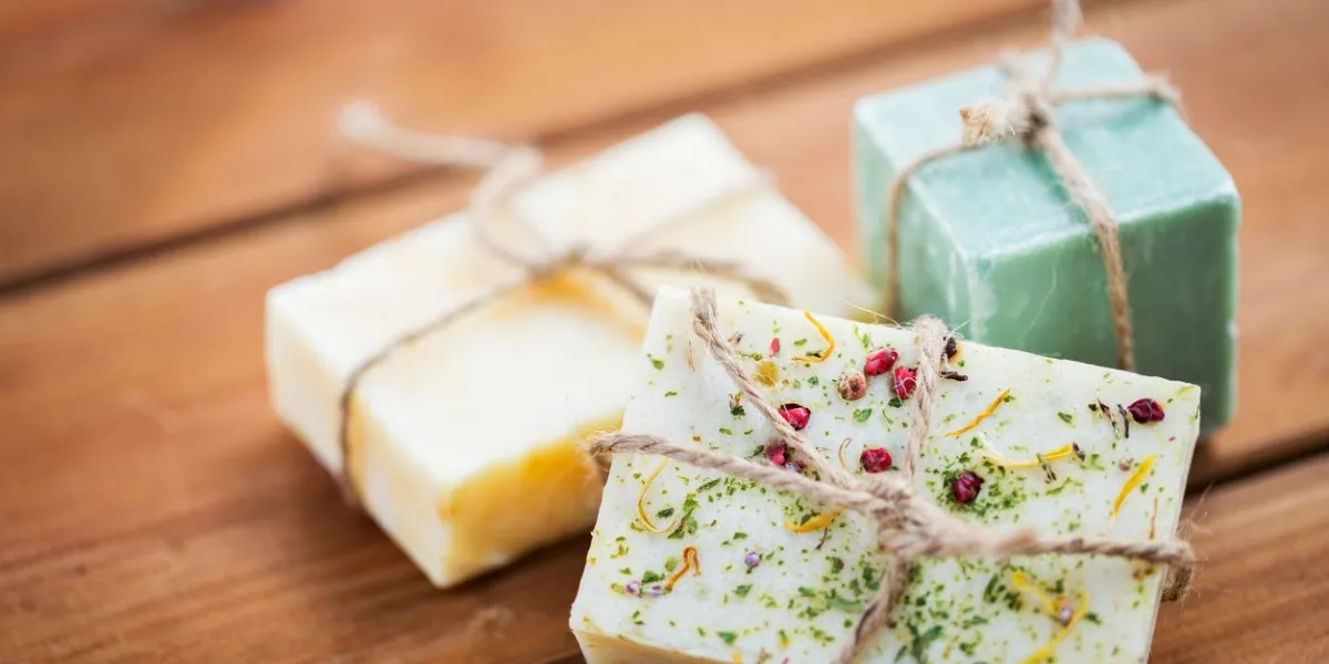 beauté, spa, soins du corps, concept de bain et cosmétiques naturels - gros plan de barres de savon à la main sur la table en bois