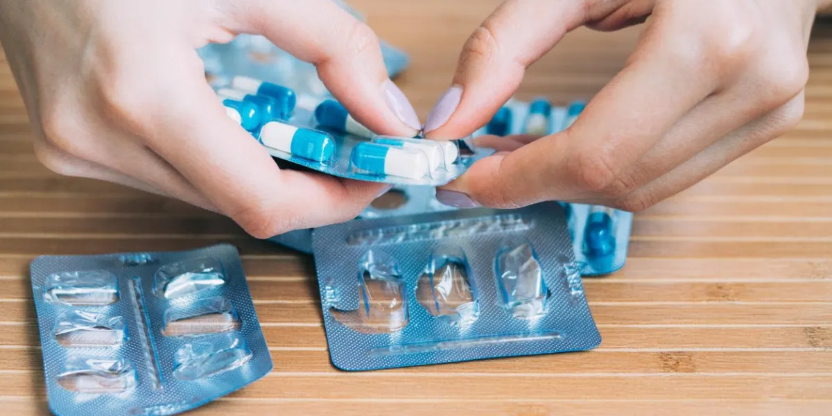 mains féminines sortir la tablette de la plaquette thermoformée