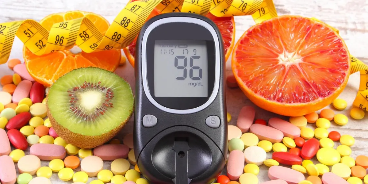 glucose meter with result of measurement sugar level, tape measure, fresh fruits and medical tablets or supplements, concept of diabetes, slimming, healthy lifestyle and nutrition