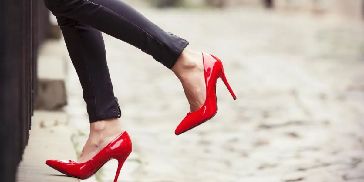 femme portant un pantalon en cuir noir et des chaussures à talons hauts rouges