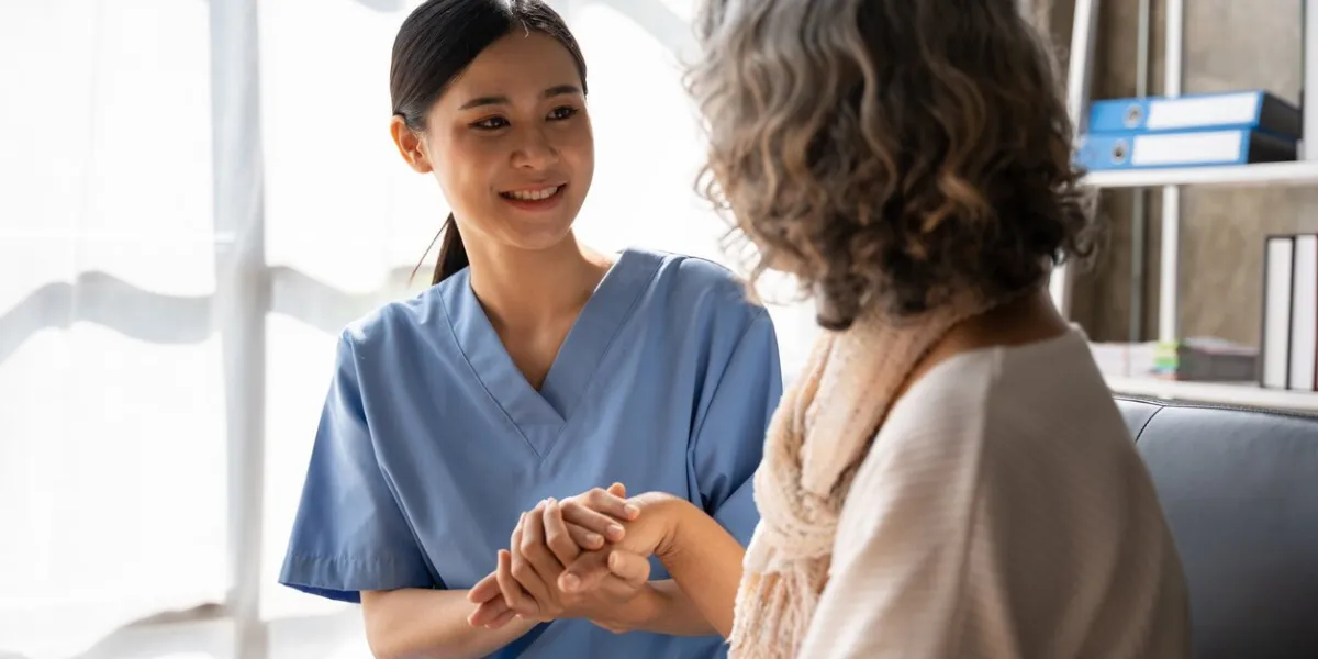 asian young nurse supporting elderly patient disabled woman in hospital elderly patient care concept