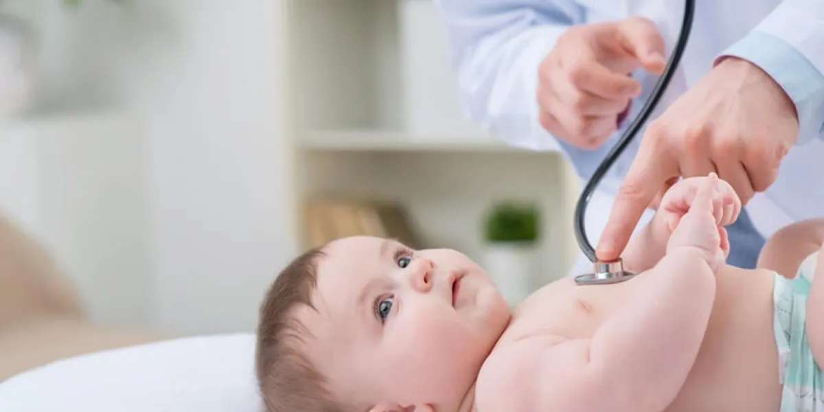 si beau monde pédiatre professionnel tenant stéthoscope et examiner bébé tout en étant attiré dans le travail
