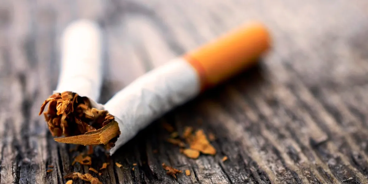 une image de près d'une cigarette cassée sur un dessus de table en bois