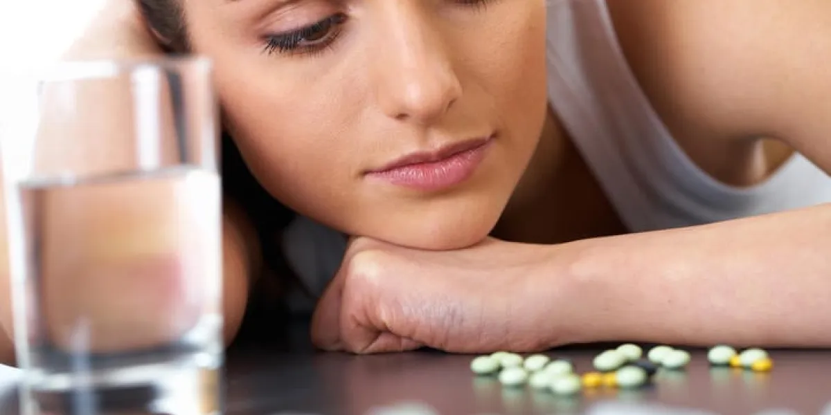 a souligné la jeune brune séduisante avec des pilules et un verre d'eau