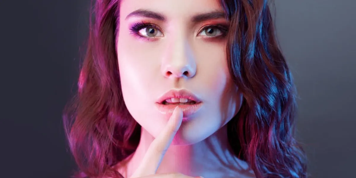 portrait de jeune belle fille aux cheveux noirs, au milieu des projecteurs l'effet de la tonification, boîte de nuit