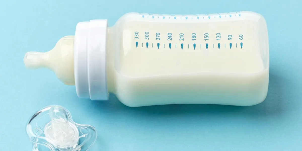 bouteille de lait bébé et sucette sur fond bleu