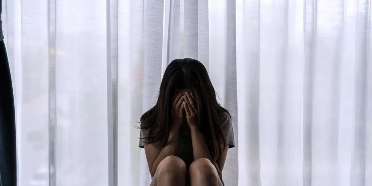 lonely young woman feeling depressed and stressed sitting in the dark bedroom, negative emotion and mental health concept