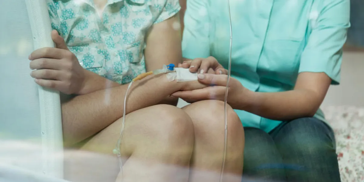 jeune infirmière attentionnée tenant la main de son jeune malade