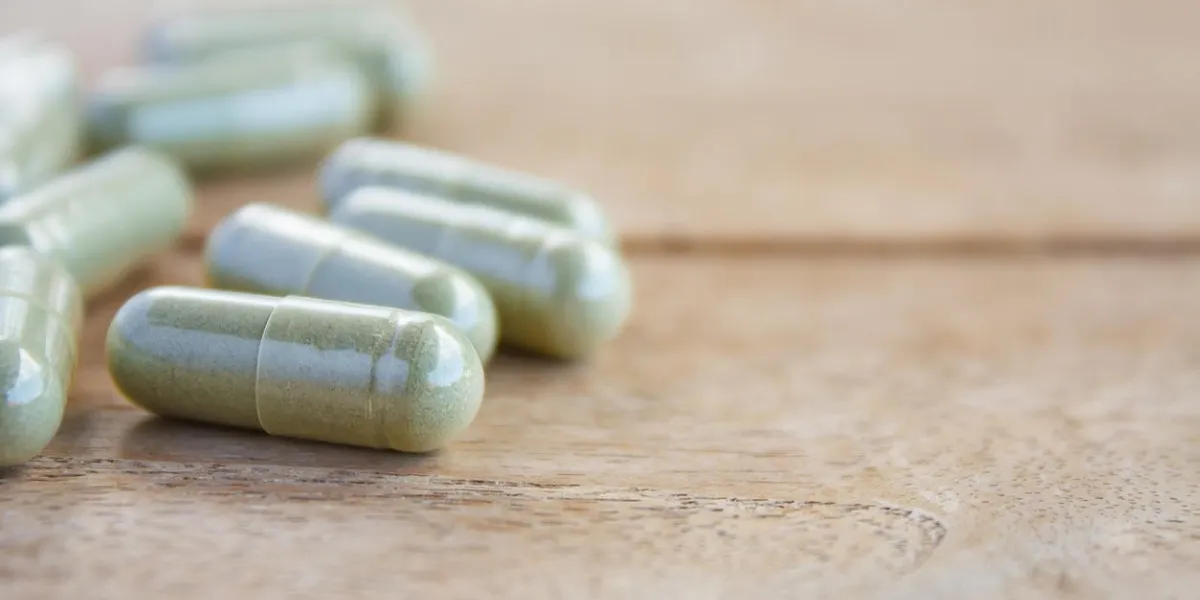 capsules à base de plantes sur la table en bois