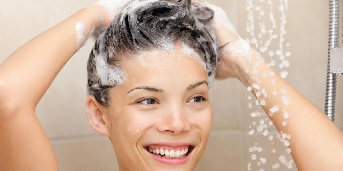 femme, lavage, cheveux, à, shampooing, mousse, dans, douche, sourire, heureux, regarder, courant, eau chaude, beau, course mélangée, asiatique, chinois, caucasien, modèle féminin, dans, salle bains, dans, douche, laver cheveux, à, shampooing