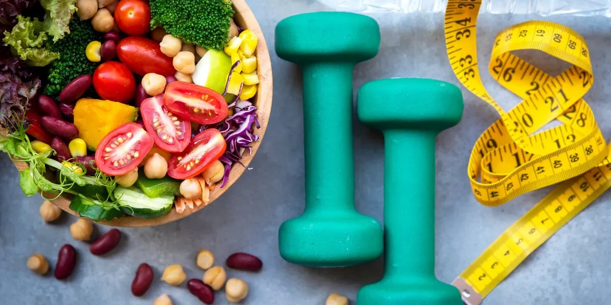 fresh vegetable salad and healthy food for sport equipment for women diet slimming with measure tap for weight loss on wood background healthy sport concept