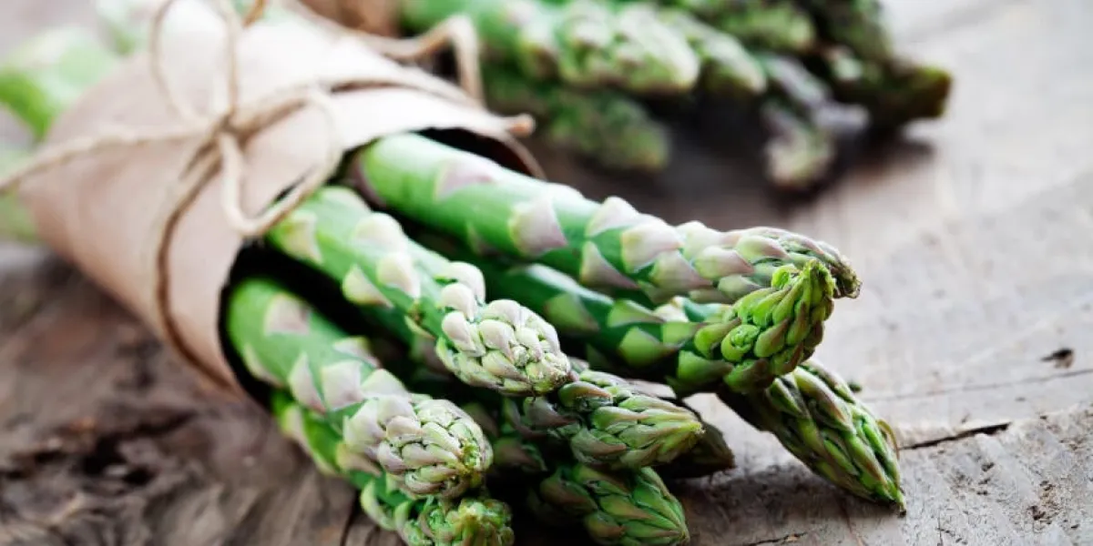 tas d'asperges fraîches sur la table en bois