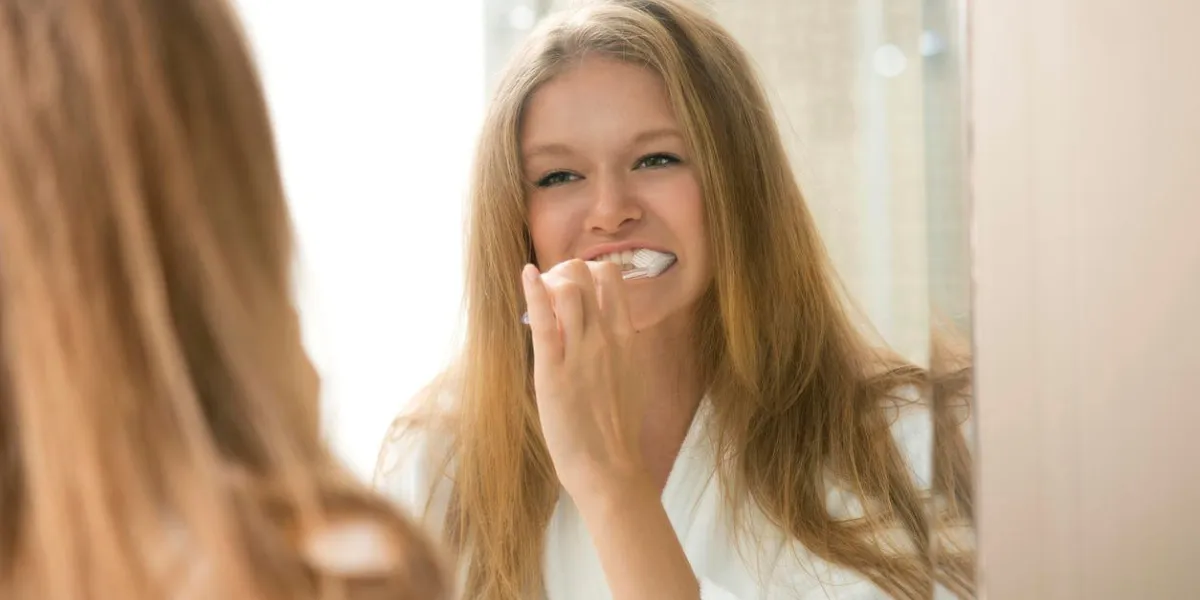 portrait of attractive woman brushing teeth in bathroom, morning routine of girl brushing her teeth, beautiful girl brushing her teeth in the morning
