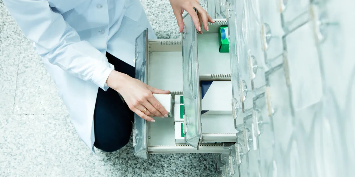 high angle view of pharmacist taking medicine from drawer copy space