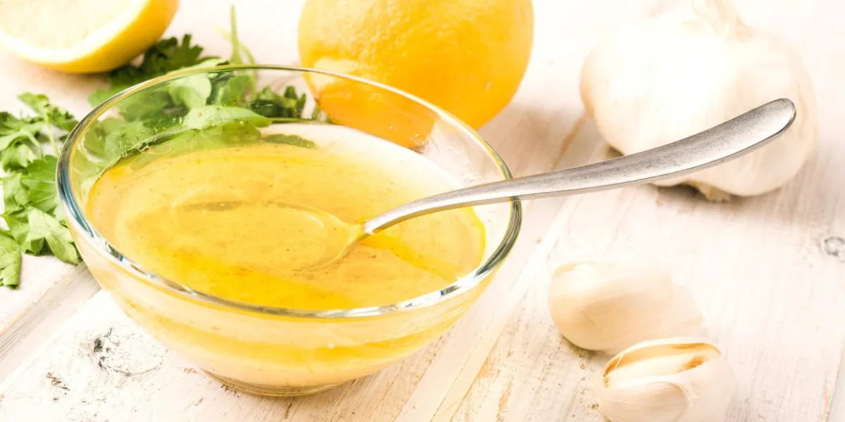 sauce vinaigrette dans un bol en verre, sur bois blanc