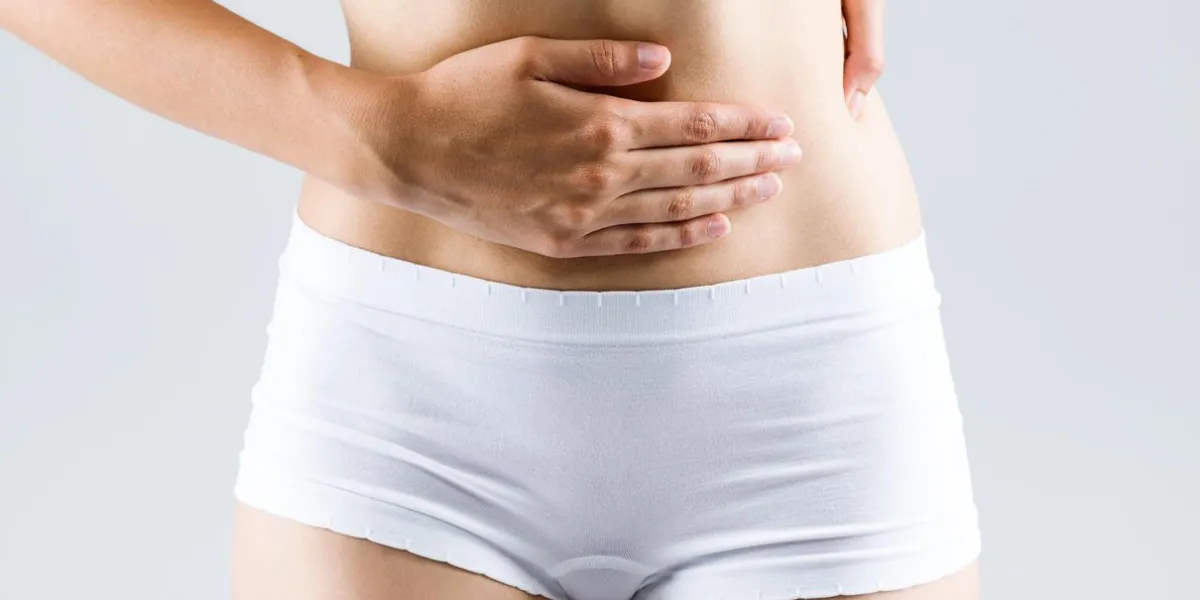 portrait de la belle jeune femme avec les mains sur le ventre-estomac