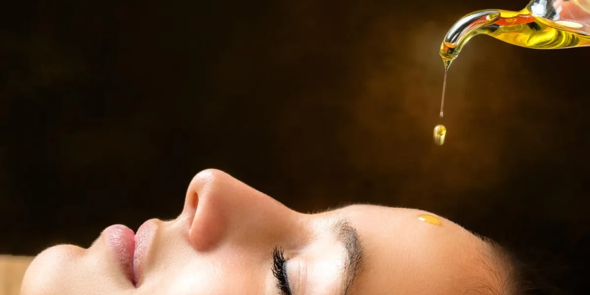macro close up portrait of young woman at ayurvedic massage session with aromatic oil dripping on face