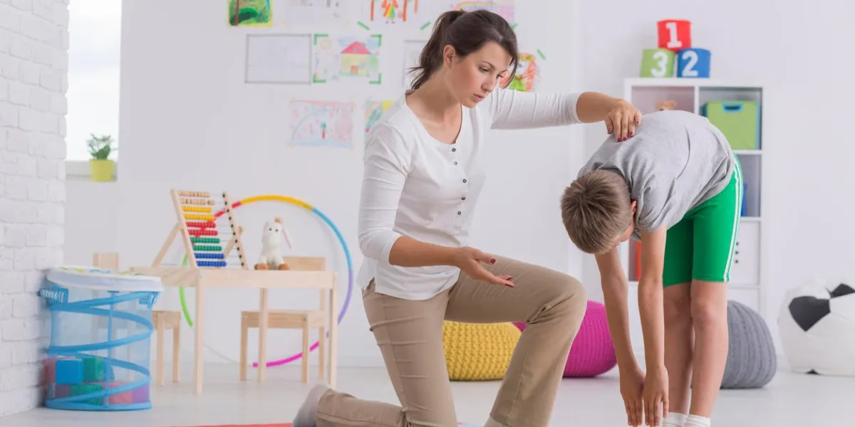child standing forward bend while exercising with physiotherapist