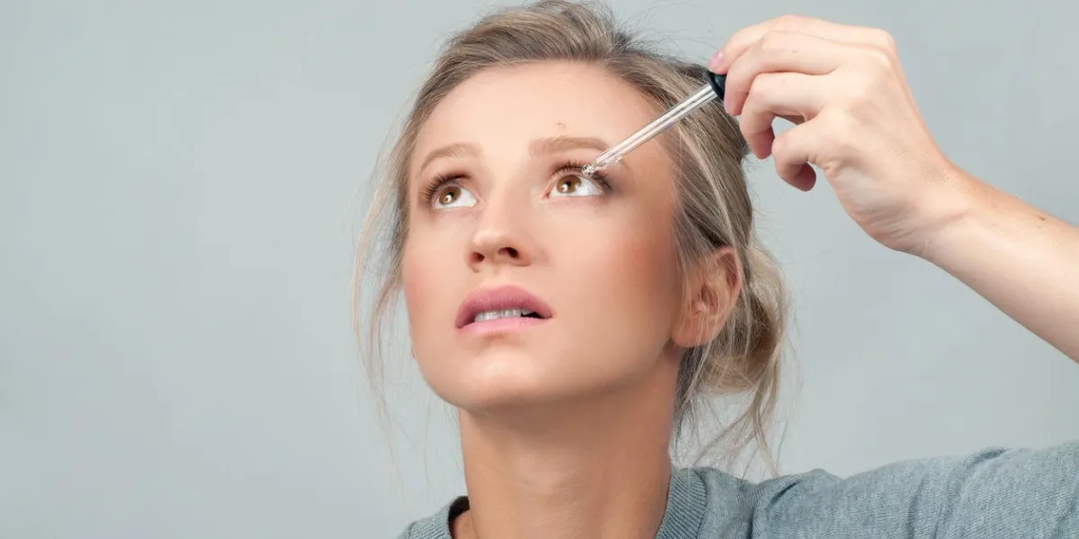 vision and ophthalmology medicine closeup of beautiful woman applying eyedrops in her eyes