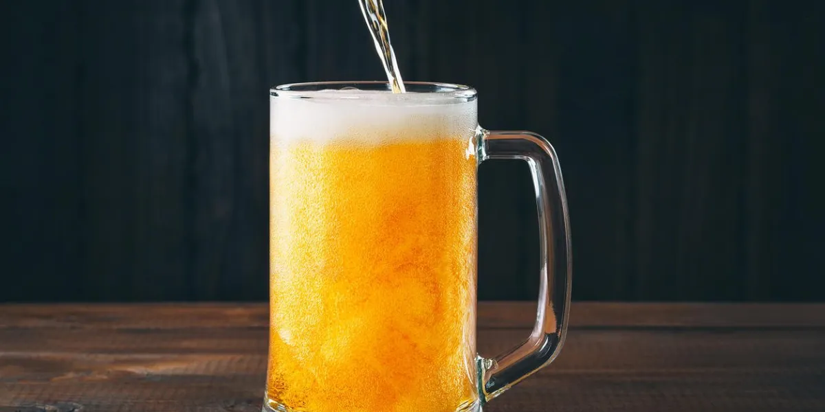 craft beer poured into a pint glass on the wooden background