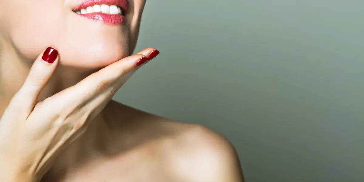 femme nue souriante touchant son menton avec la main