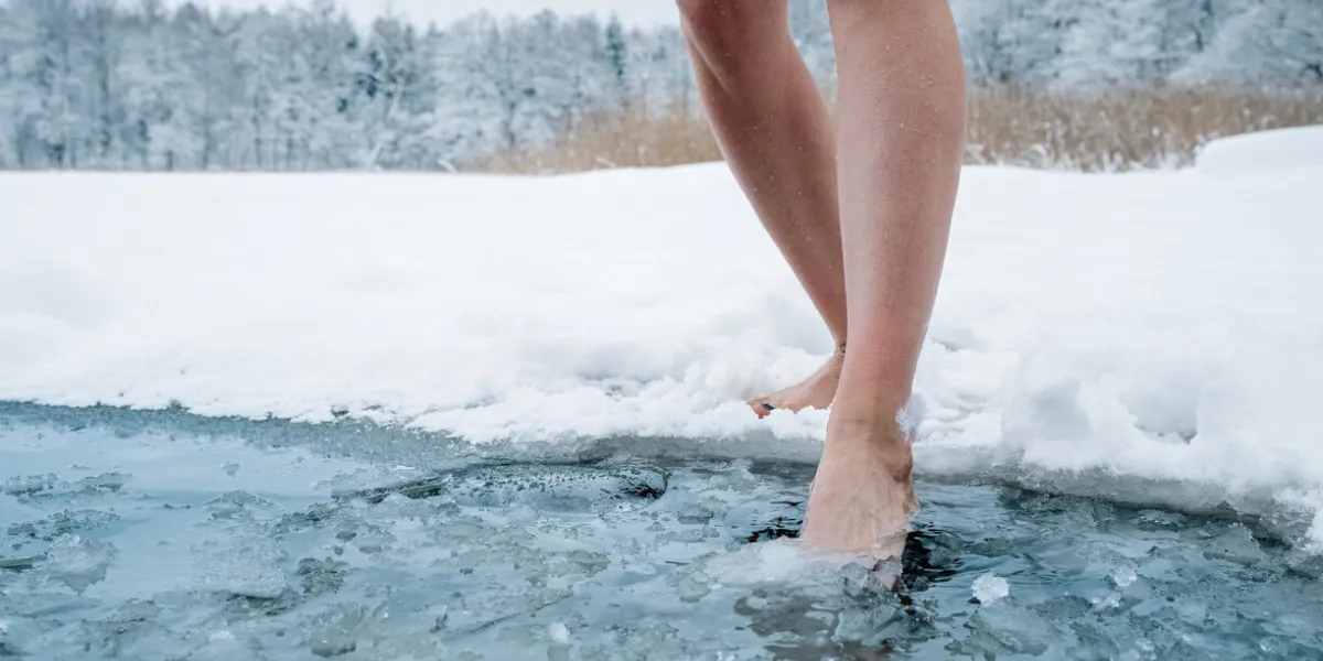 close up of female legs getting into ice cold water