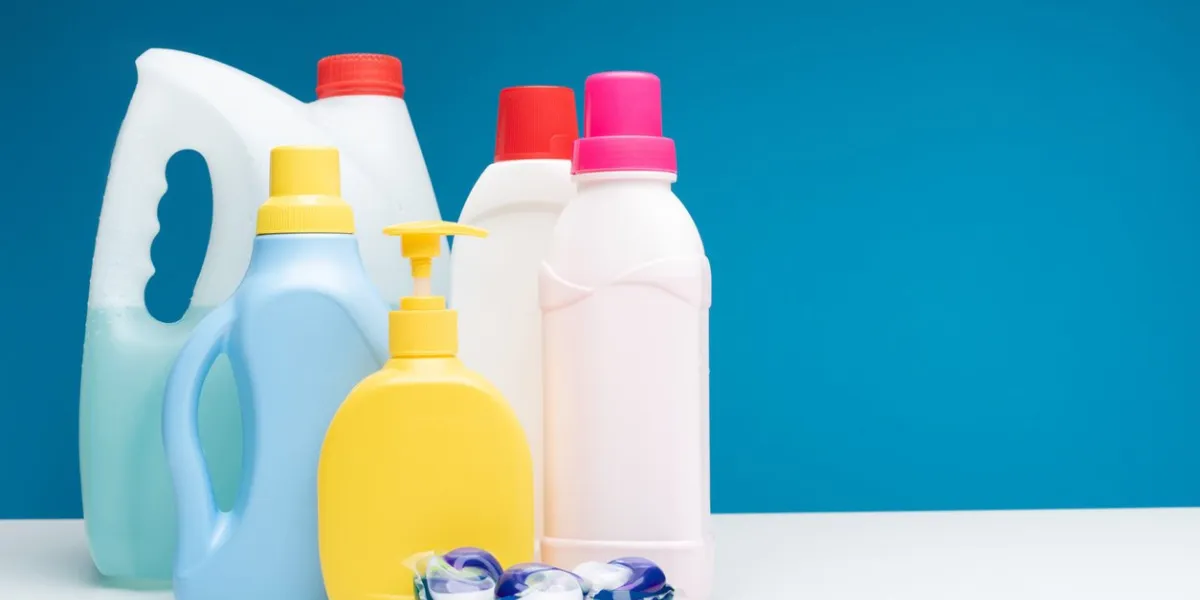close up of washing capsules lying together with different washing liquids, soap, softener and bleach copy space in right side