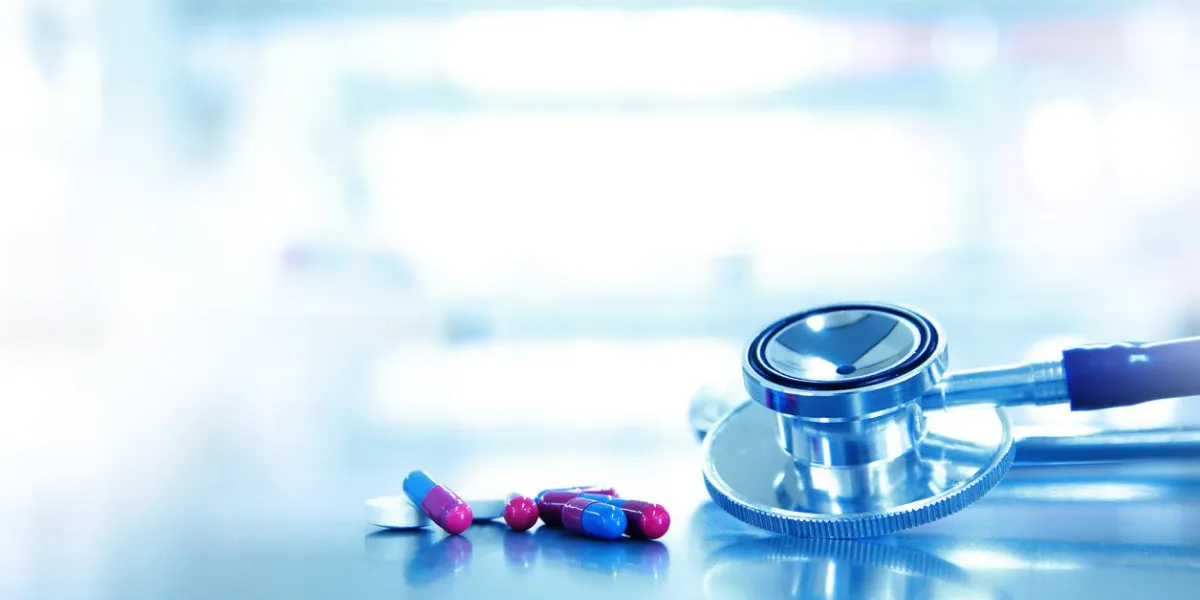 metal stethoscope for doctor diagnosis and medical drug pill and capsule on the table in blue health science laboratory background