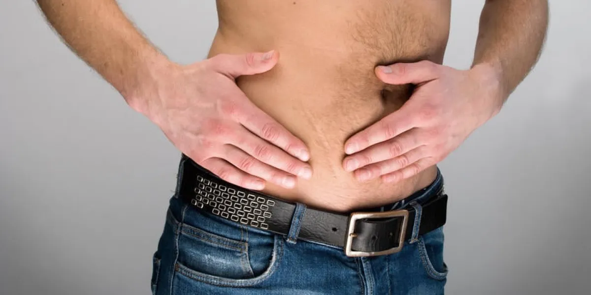 gros plan sur l'estomac de l'homme dans la douleur