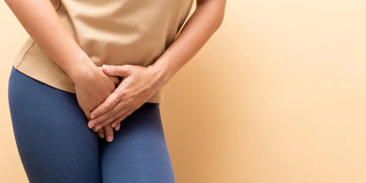 closeup sick woman with hands holding pressing her crotch isolated on background