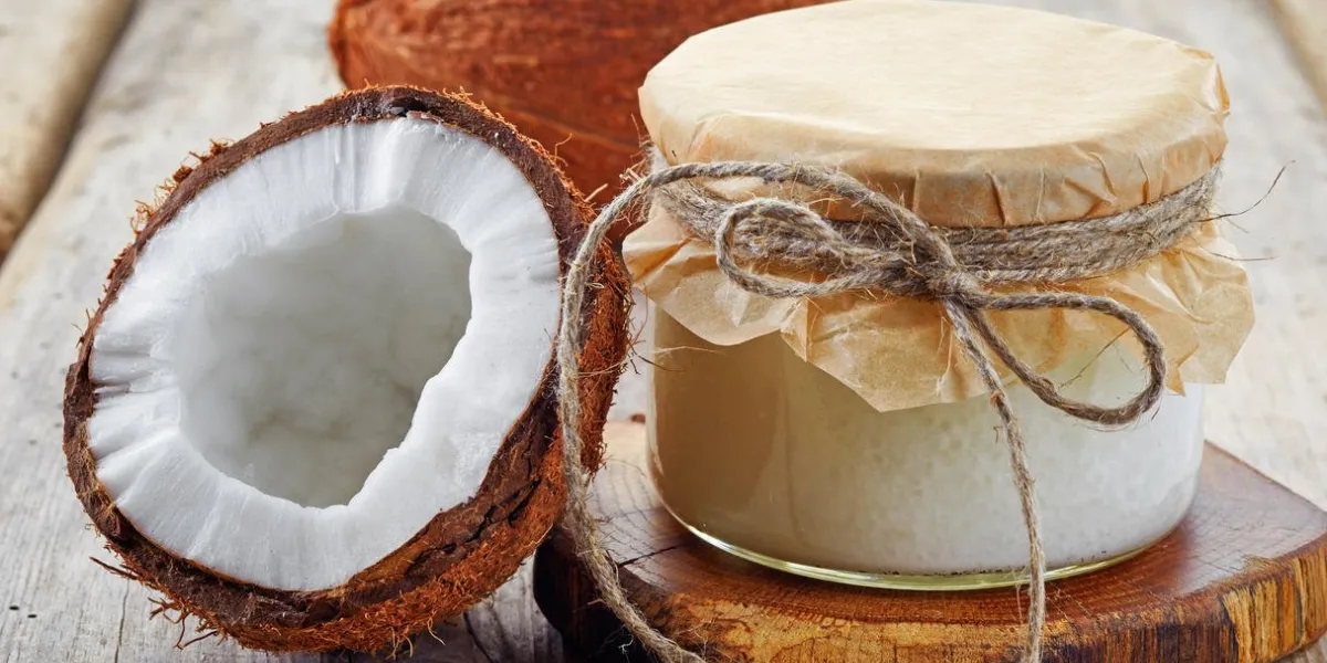pot d'huile de coco et de noix de coco fraîche sur la table en bois
